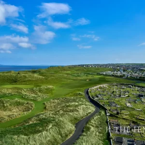 Hole #1 at Ballybunion shows its history, winding next to Killehenny Cemetery.