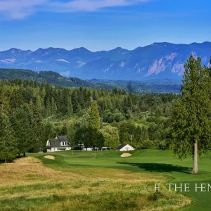 A majestic mountain range frames the treeline surrounding Aldarra Golf Club's 8th hole.